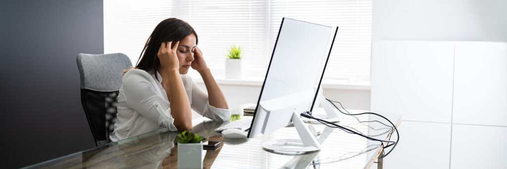 A tired woman, in front of her computer
